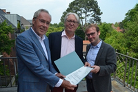 Vorstand Rüdiger Wiechers (links im Bild) überreichte den Bescheid seiner Stiftung „Stædte für Menschen“ an Dr. Christoph Spieker und Stefan Querl vom Team der Villa ten Hompel. Foto: Max Dahlmer Foto