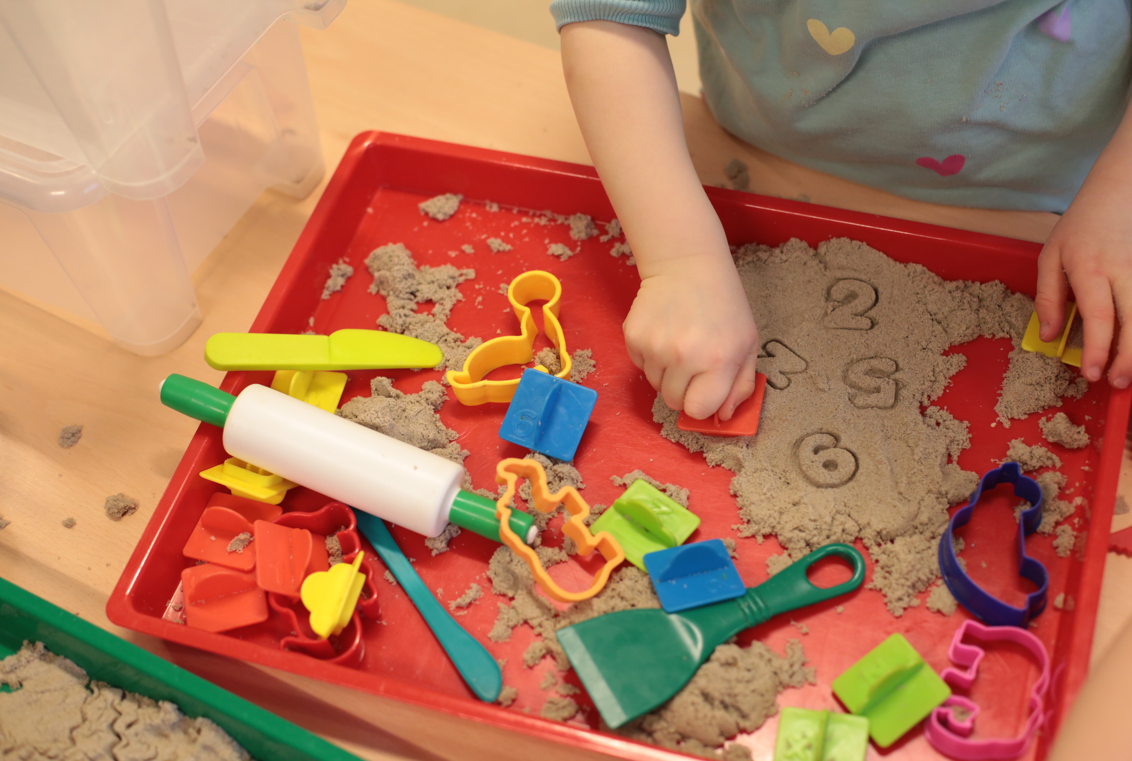 Kind spielt mit Sand und Spielzeug