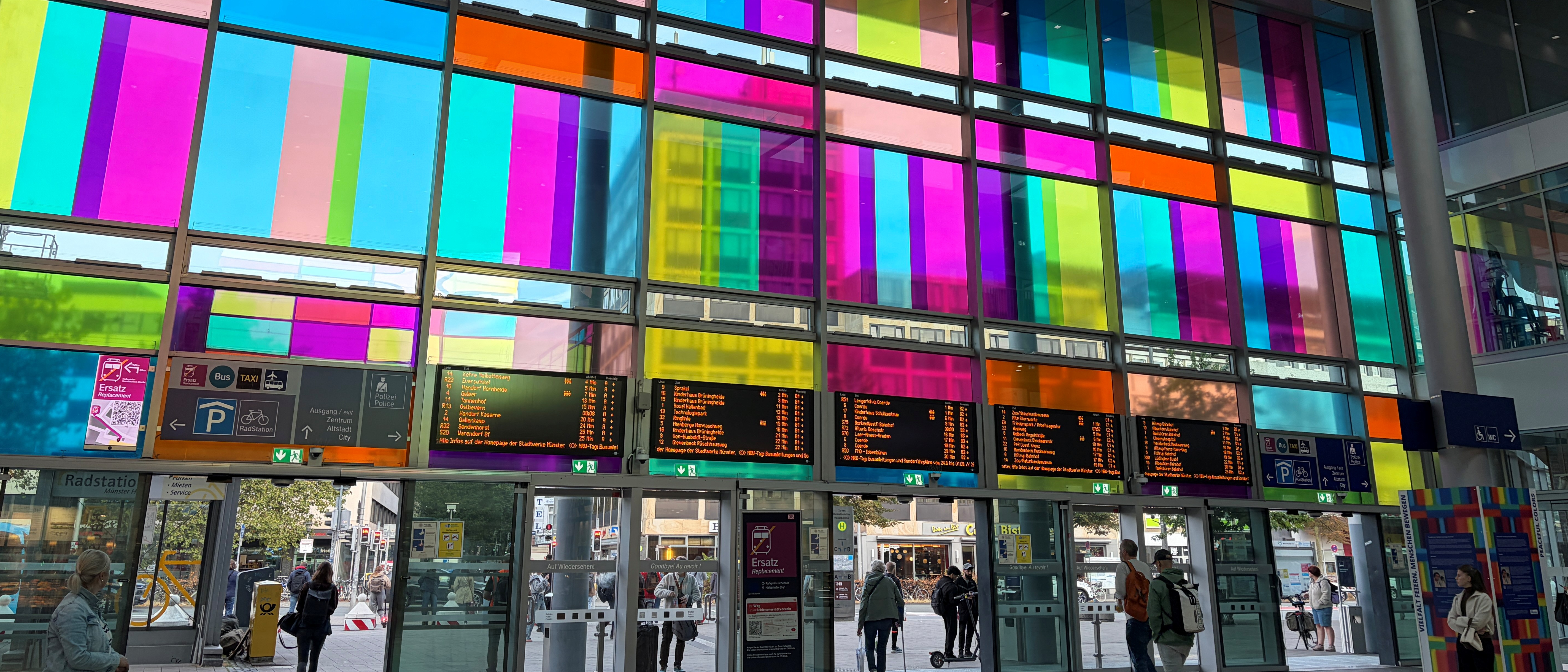 Die Scheiben am Bahnhofs-Haupteingang in Münster sind mit bunten Folien geschmückt.