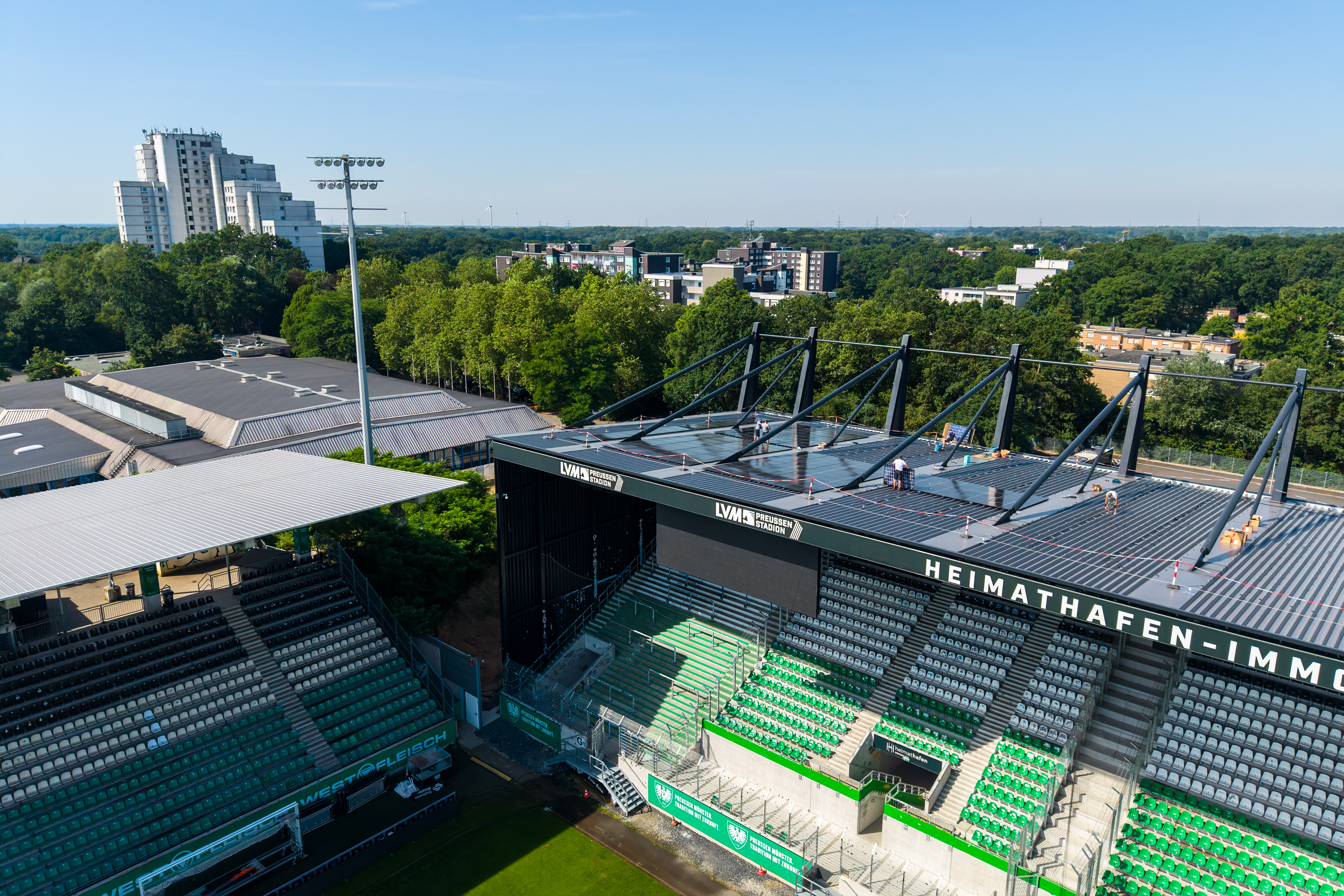 Blick auf die Westtribüne des Fußballstations LVM mit ersten montierten PV-Anlagen