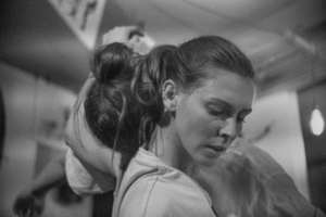 Eine Tänzerin steht seitlich. Eine Tänzerin legt hinter ihr den Kopf auf ihre Schultern. Es sind nur die Oberkörper mit den Köpfen abgebildet.