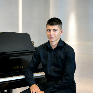 Foto eines Jungakademisten mit Instrument Klavier