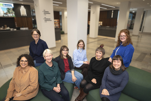 Gruppenfoto: acht Frauen sitzen im Foyer und lächeln