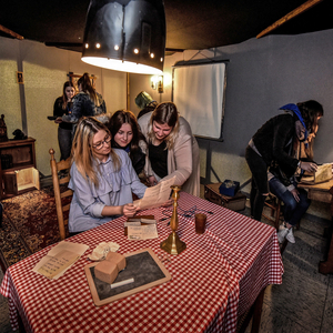 Teilnehmende des Escape Rooms sichten Hinweise