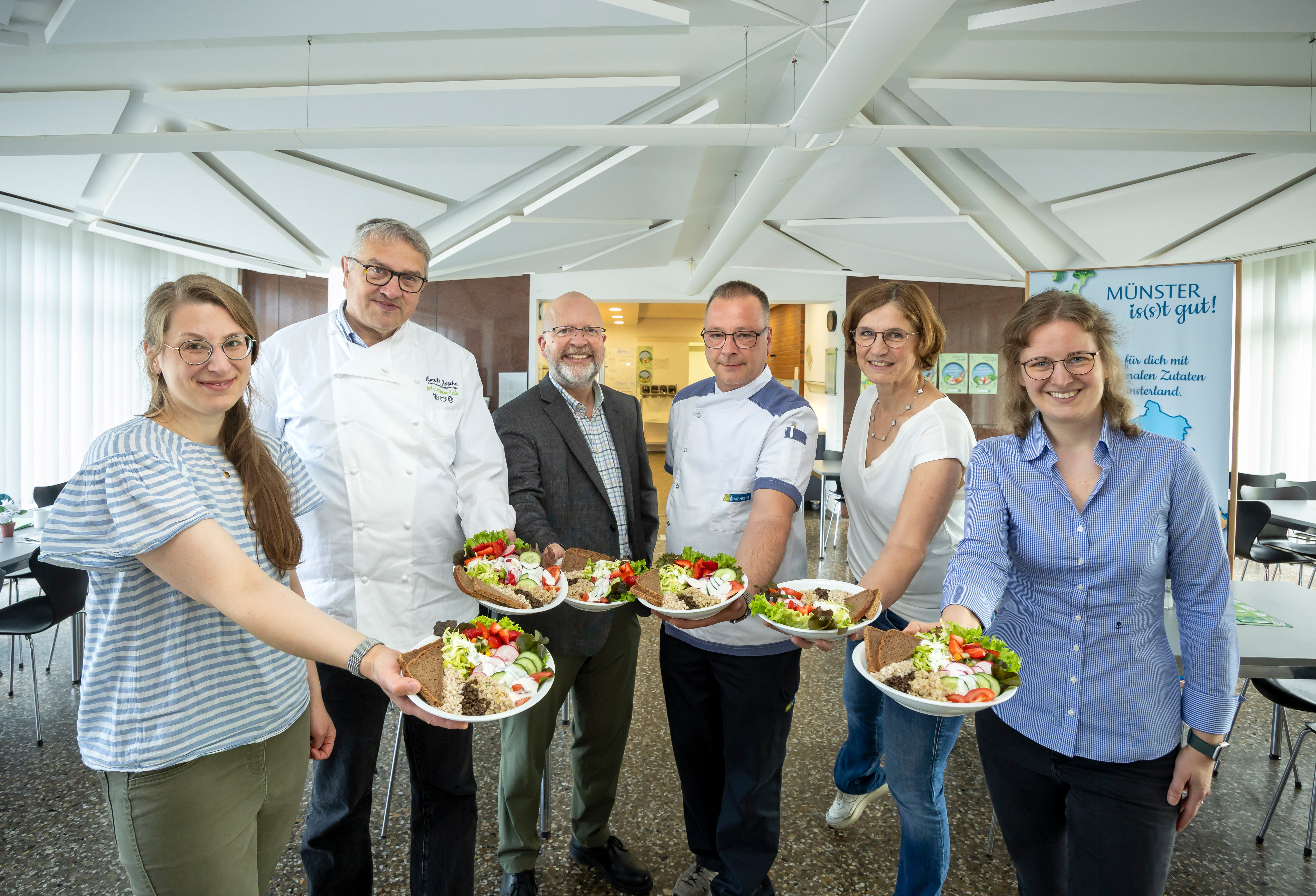 Gruppenbild: Die Personen halten Teller mit Gerichten