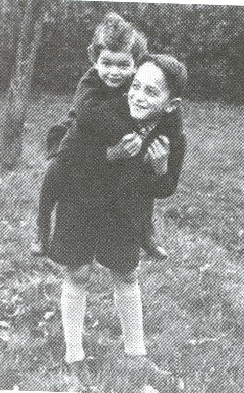 Schwarz-Weisß Foto: Ein fröhlicher kleiner Junge trägt ein kleines Mädchen auf dem Rücken.