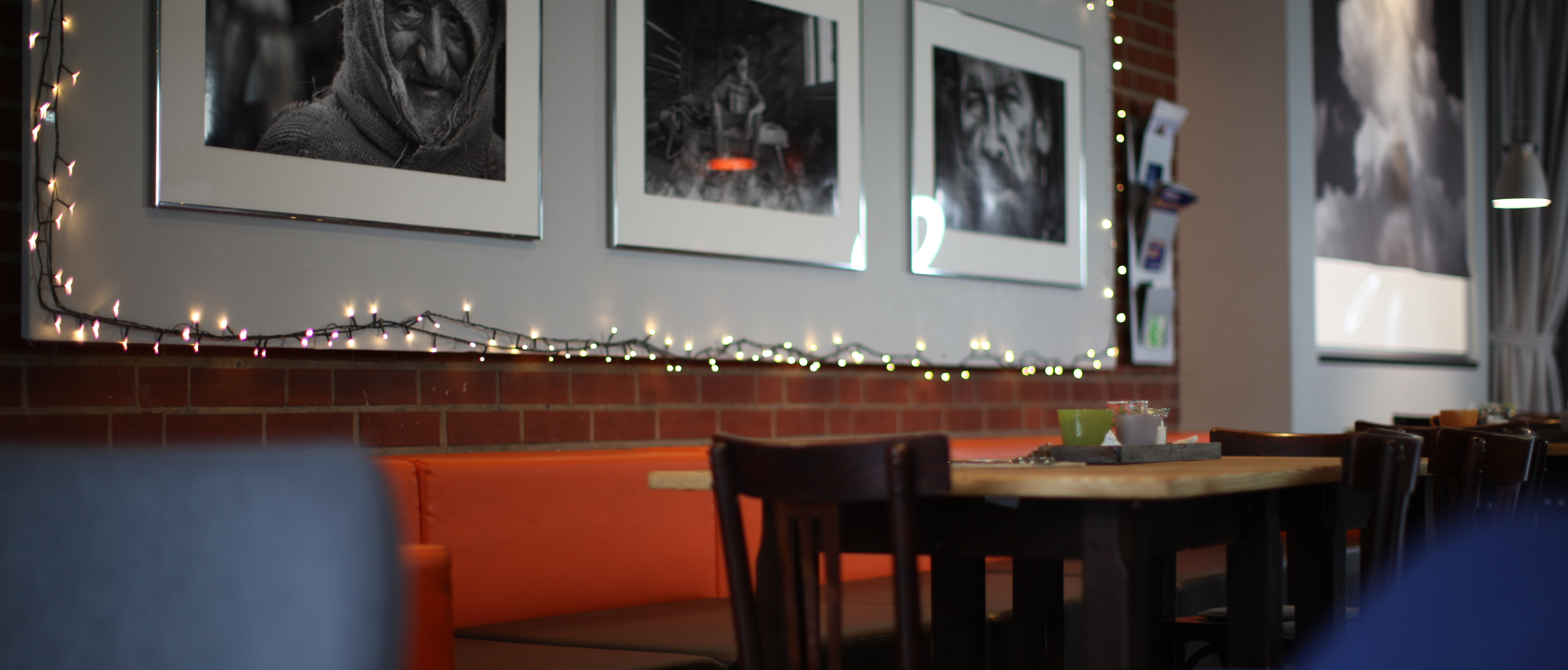 Sitzplätze im Café-Lorenz; an der Wand große schwarz-weiß Fotografien