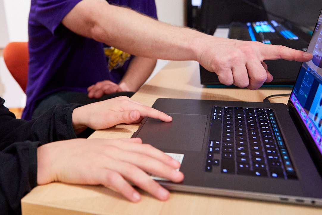 Ein Jugen und ein Mann testen einen Computer