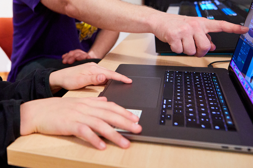 Ein Jugen und ein Mann testen einen Computer