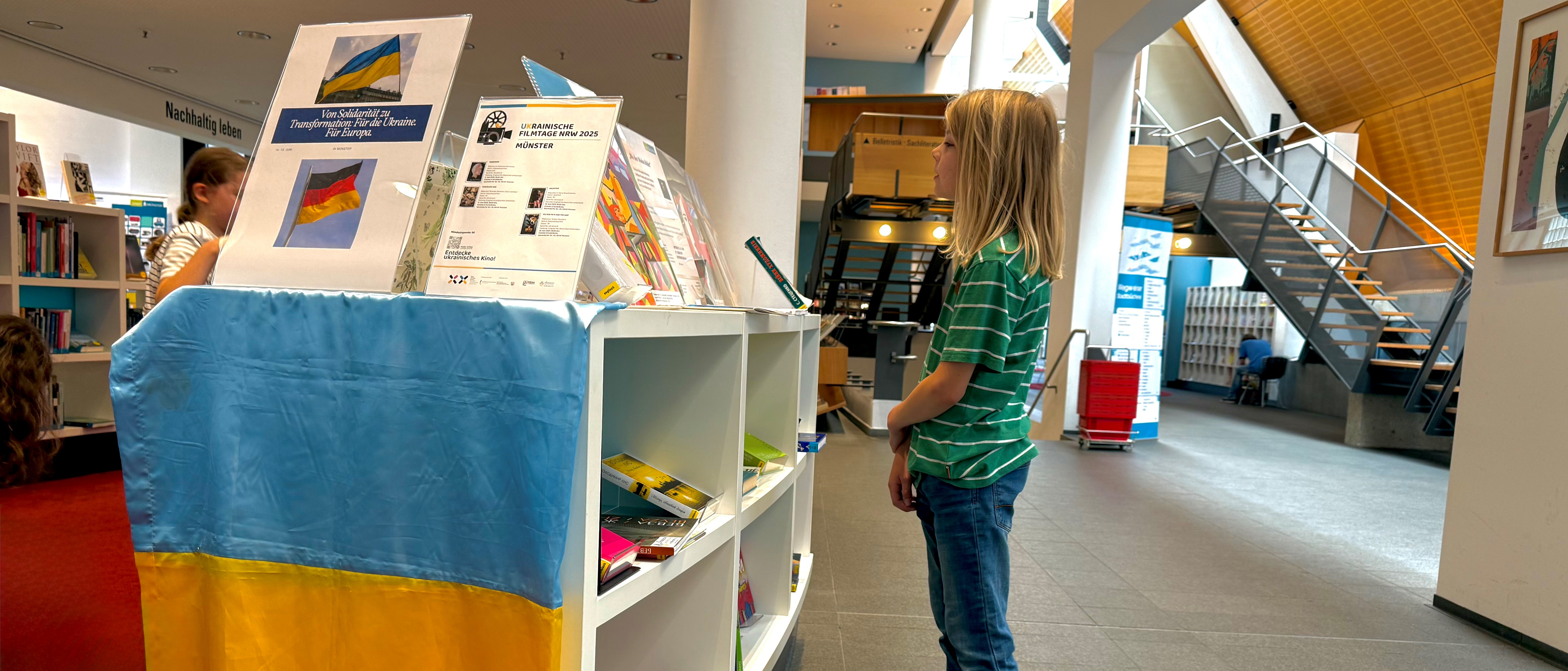 Kleiner Junge schaut sich in der Bücherei um