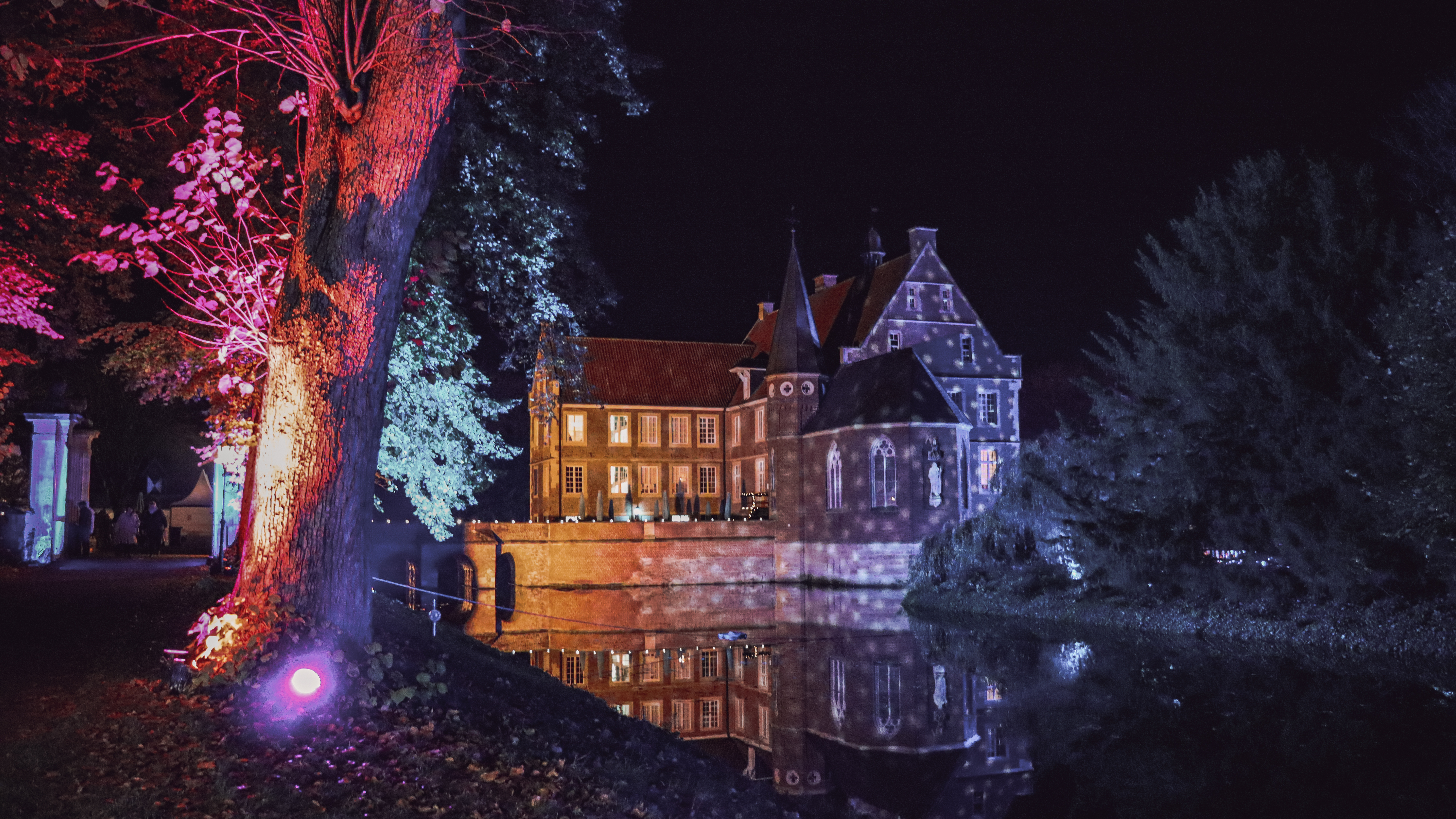 Die Burg Hülshoff in Havixbeck bunt beleuchtet in der Adventszeit.