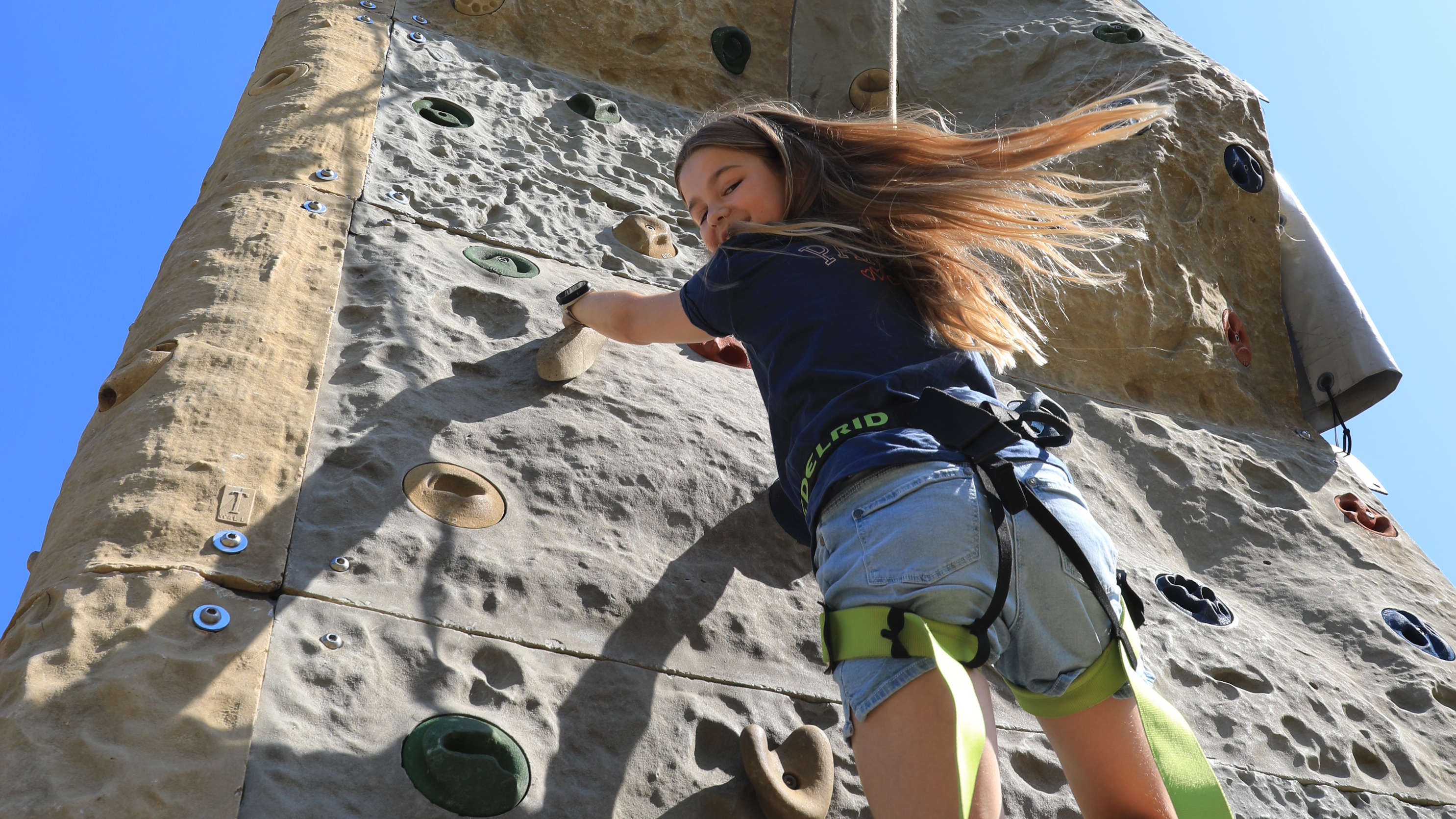 Mägchen klettert am Kletterturm