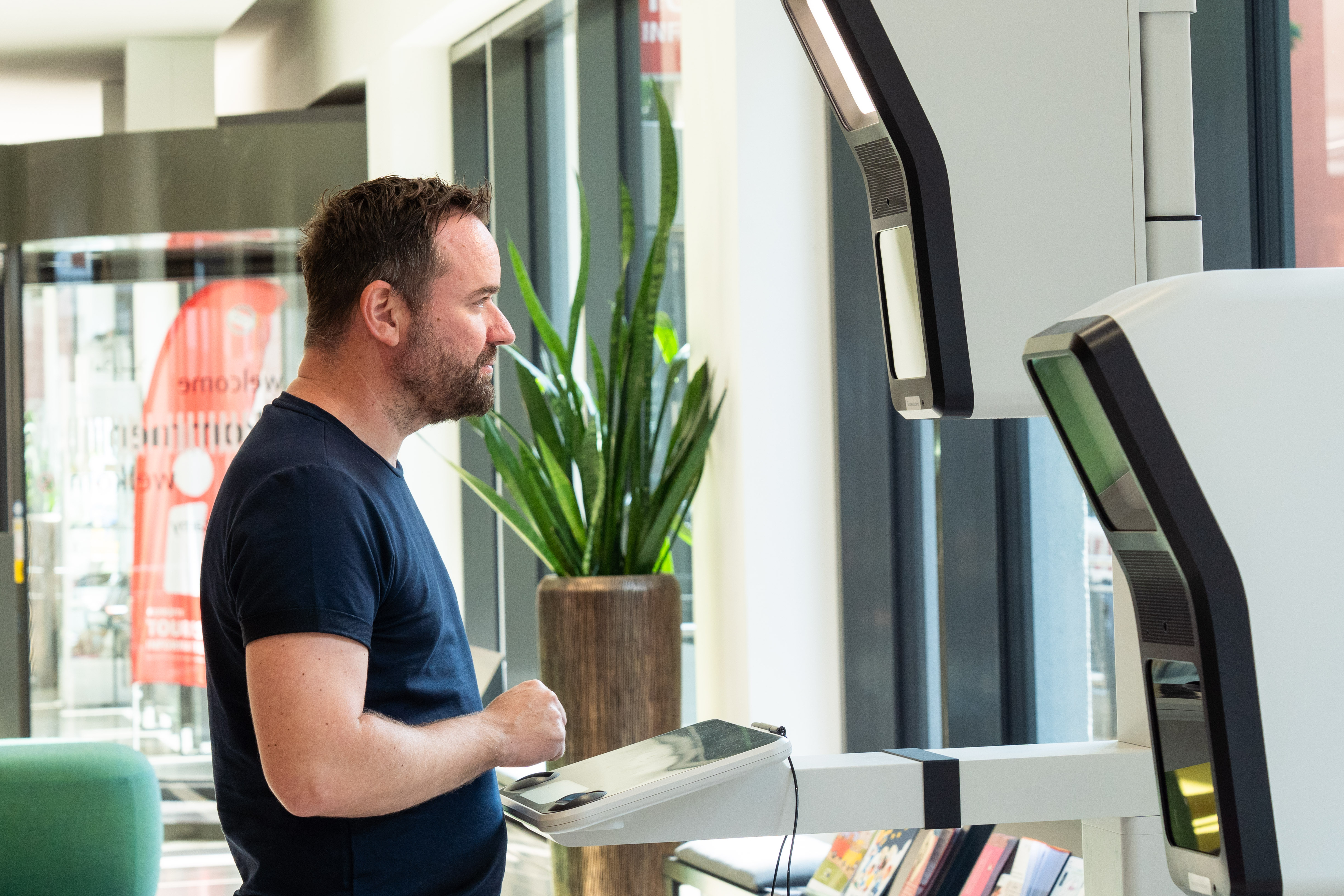 Ein Mann steht vor einem Passbild-Automaten in der Stadtverwaltung