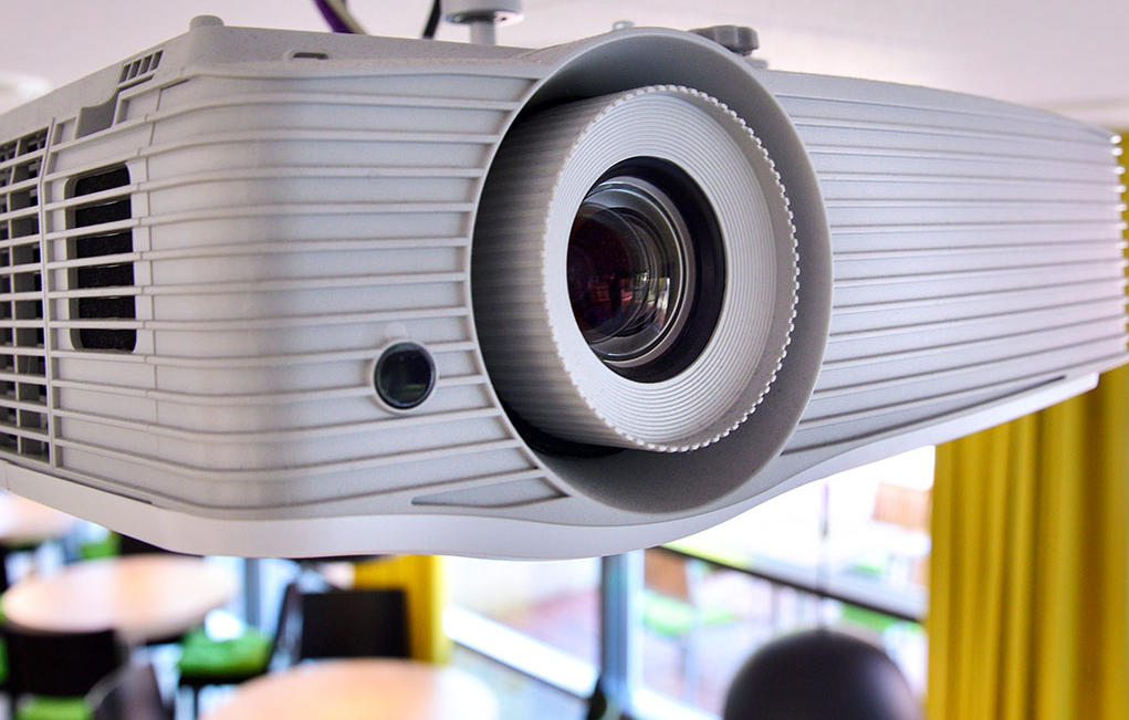 Ein Beamer hängt unter der Decke im Wuddi-Café