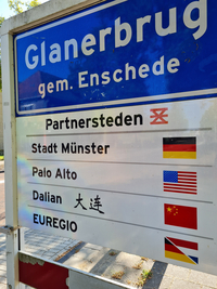 Straßenschild der Stadt Enschede mit einer Auflistung aller Partnerstädte.