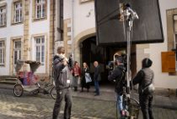 Ein Kamerateam nimmt vor einer alten Toreinfahrt eine Szene für eine neue Folge Wilsberg auf.