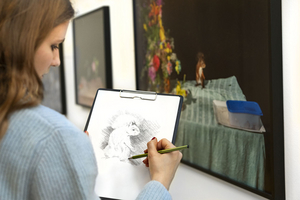 Eine Teilnehmerin zeichnet Einzelheiten von der Fotografie.