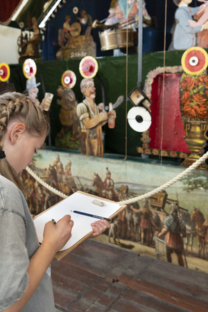 Ein Mädchen zeichnet im Ausstellungsraum die historische Schießbude vom münsterischen Send.