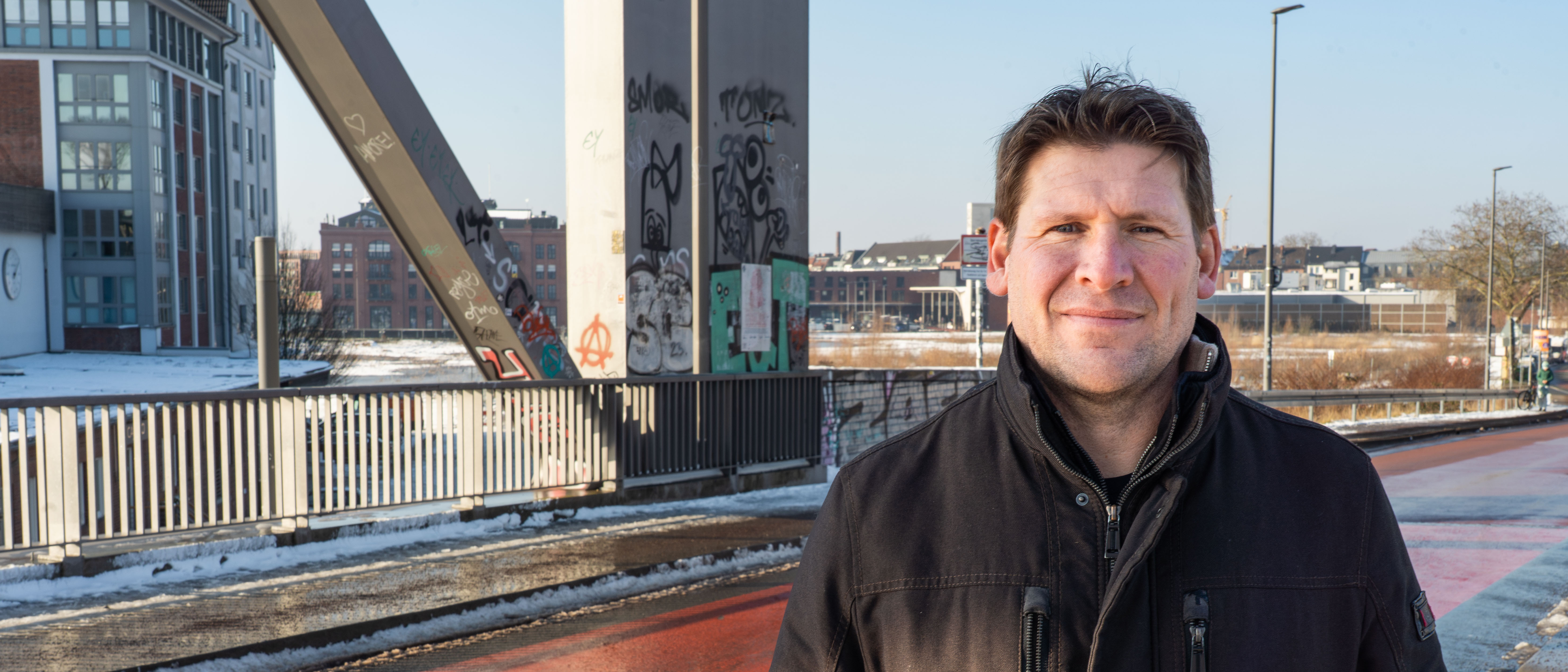 Christian Schmelter steht auf einer Fahrradstraße, neben ihm eim Fahrradstraßen-Piktogramm