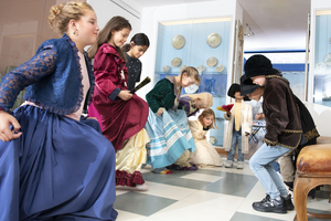 Kinder studieren kostümiert einen historischen Tanz ein.