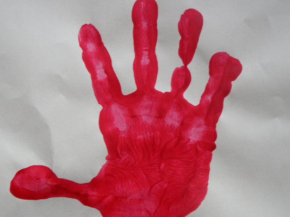 Roter Kinderhandabdruck auf weißer Fläche