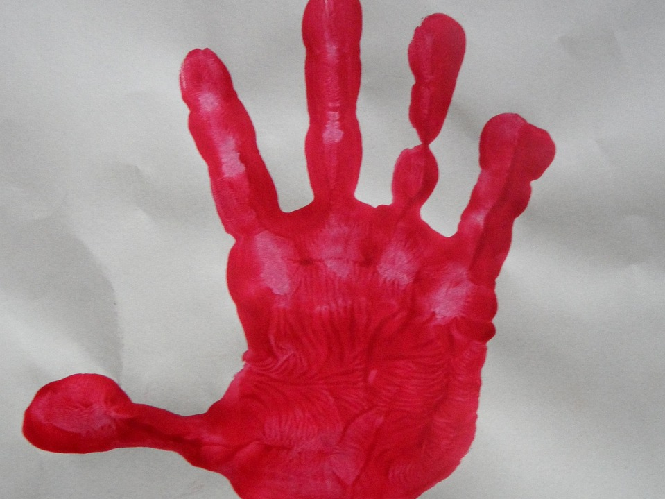 Roter Kinderhandabdruck auf weißer Fläche