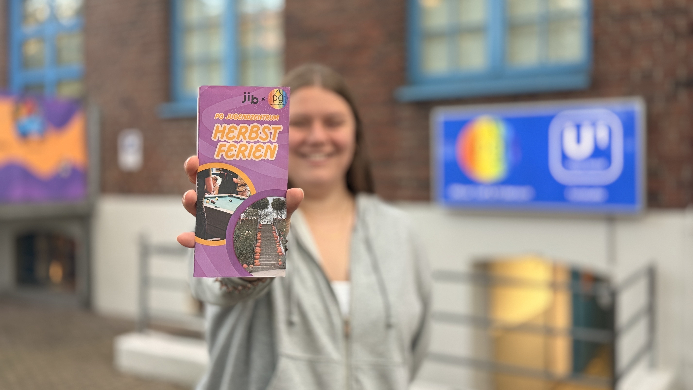 Eine Mitarbeiterin des PG mit dem Programmflyer