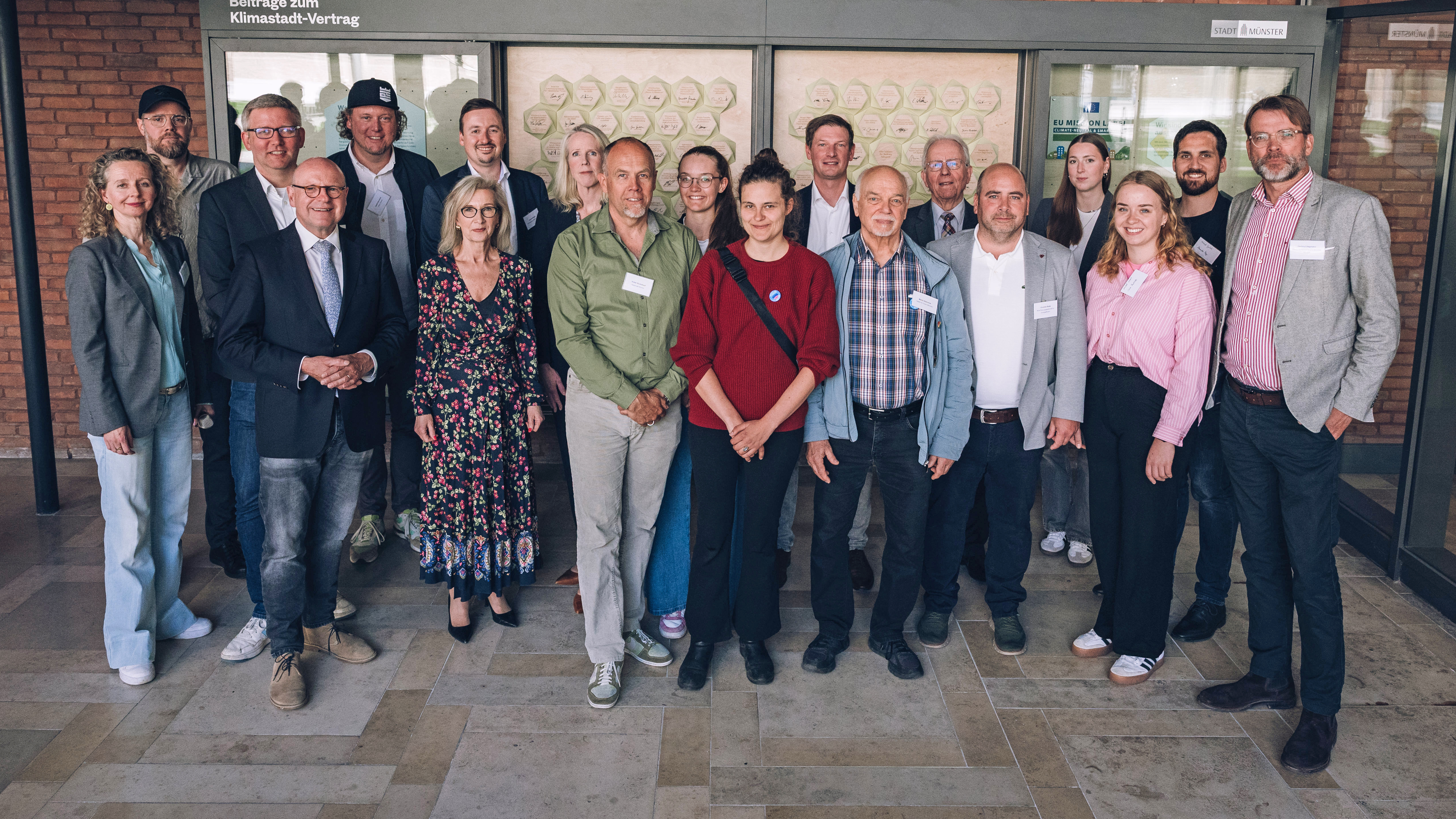 Gruppenfoto von Oberbürgermeister Markus Lewe sowie weiteren Engagierten, die neue Beiträge zum Klimastadt-Vertrag unterzeichnet haben