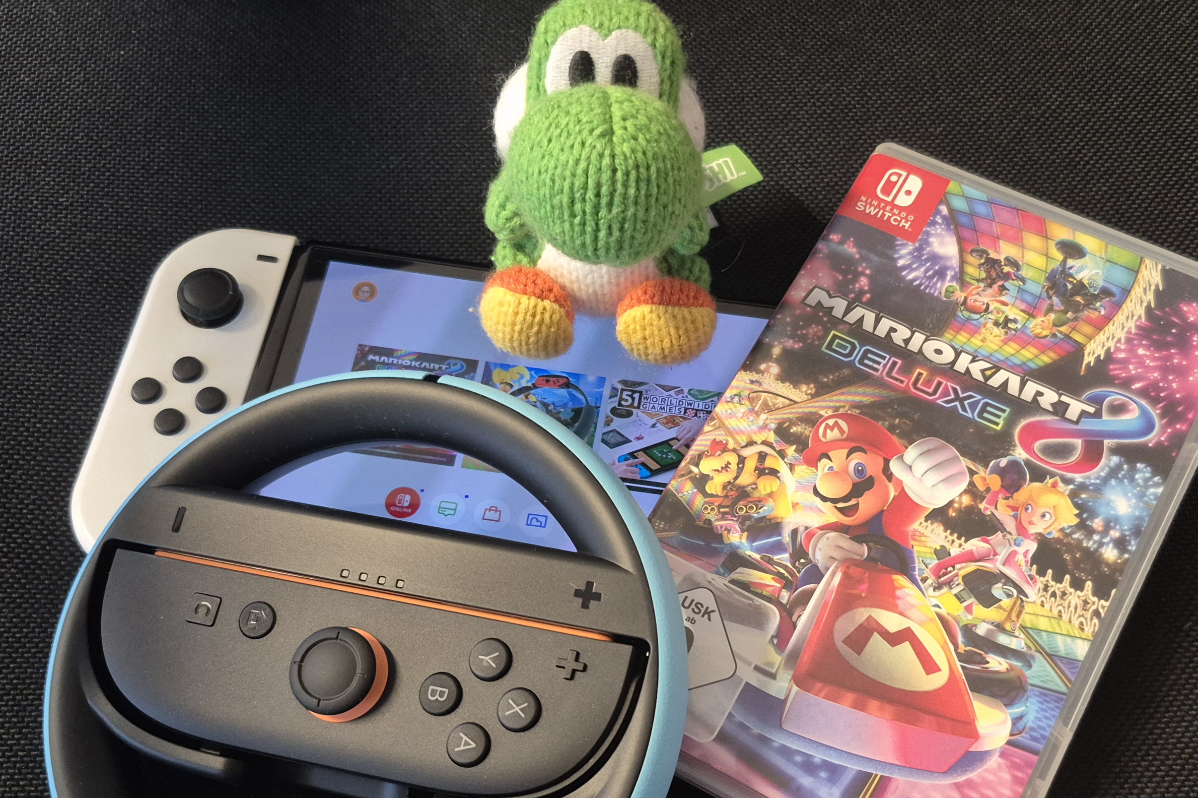 Eine Switch, ein Controller und ein Mario Kart-Game liegen bereit.