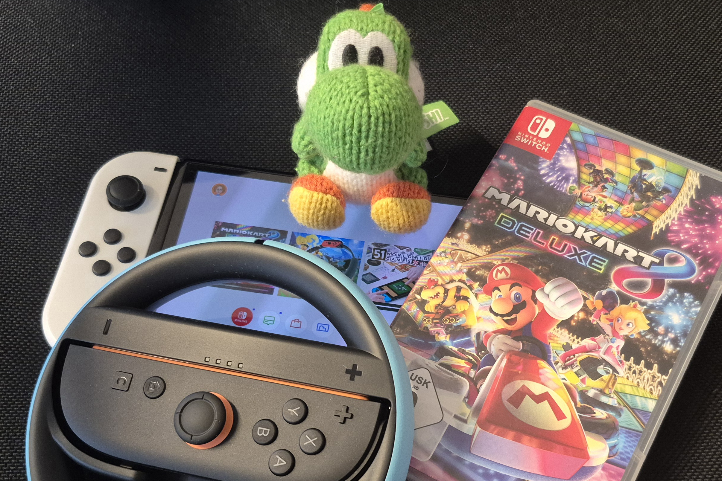 Eine Switch, ein Controller und ein Mario Kart-Game liegen bereit.