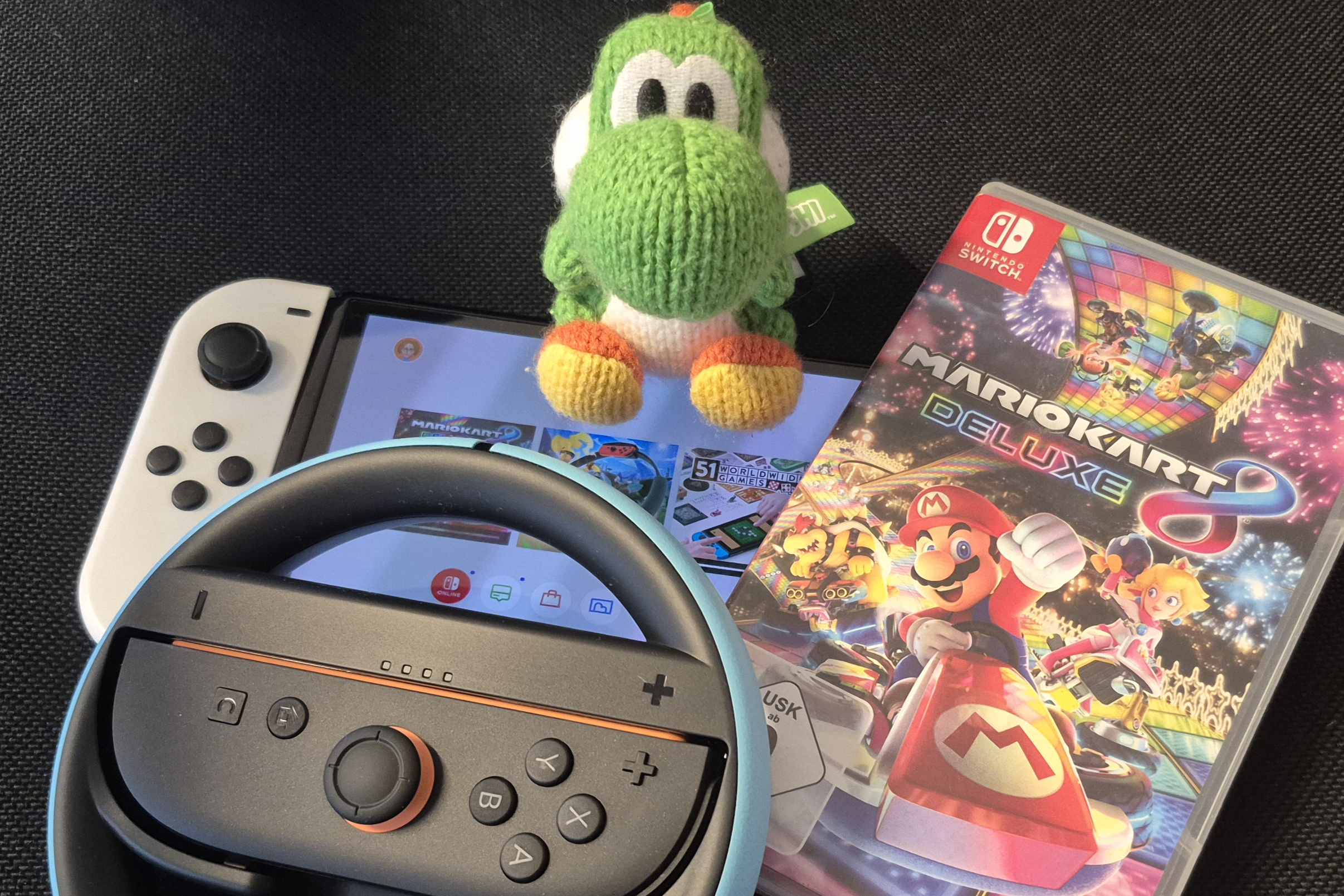Eine Switch, ein Controller und ein Mario Kart-Game liegen bereit.