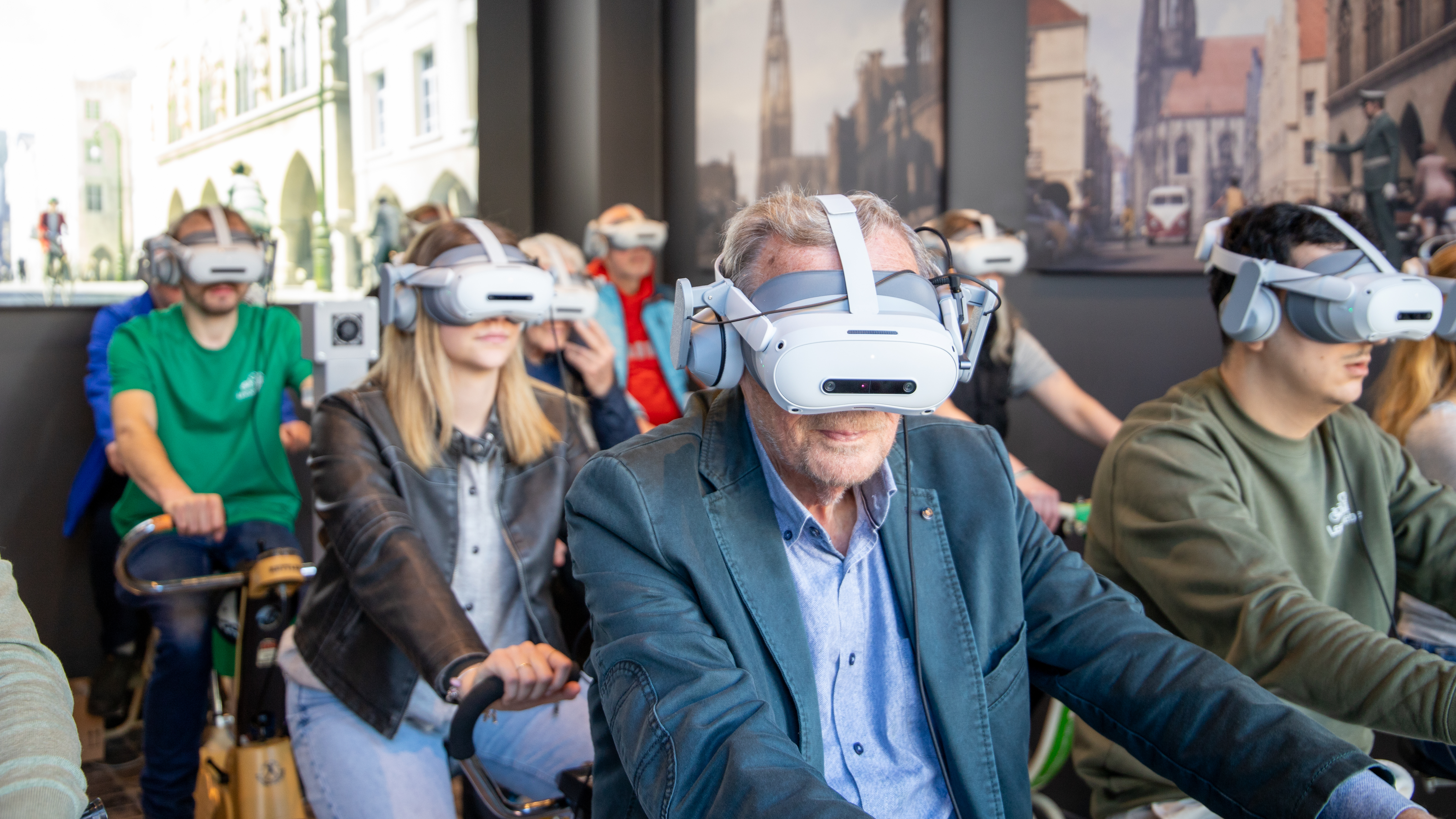 Teilnehmende sitzen auf Indoor-Fahrrädern und tragen eine VR-Brille im Leezodrom Münster.