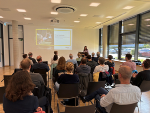 Netzwerktreffen Gebäudemodernisierung, in Stuhlreihen sitzende Personen hören einem Vortrag zu
