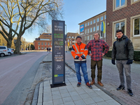 Drei Menschen stehen an der neu installierten Radverkehrszählstelle an der Bisamarckallee