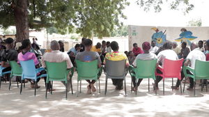 Die Schauspielerinnen und Schauspieler sitzen zum Austausch in einem Stuhlkreis.