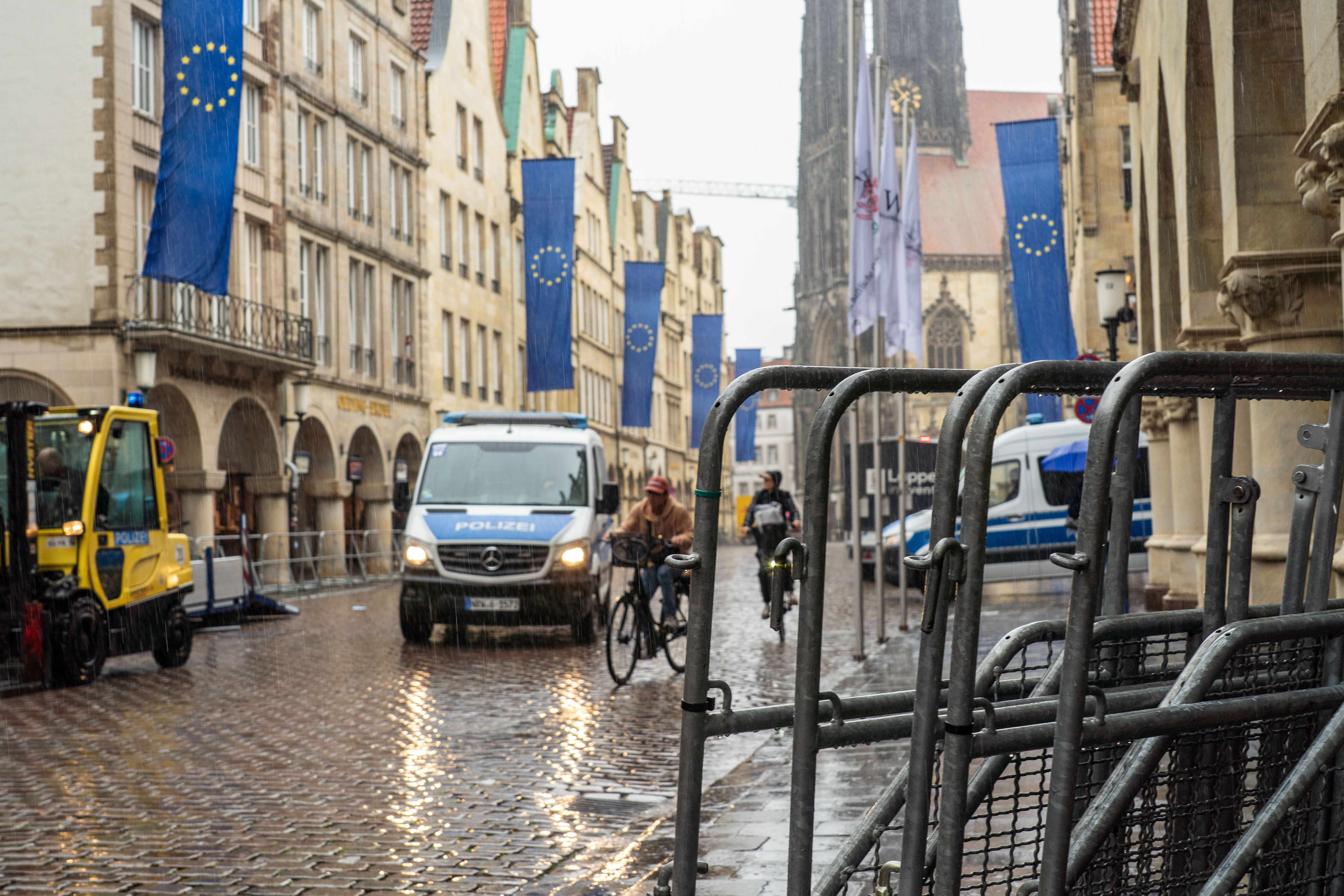 Absperrungen und ein Polizeiwagen auf dem verregneten Prinzipalmarkt mit Europaflaggen