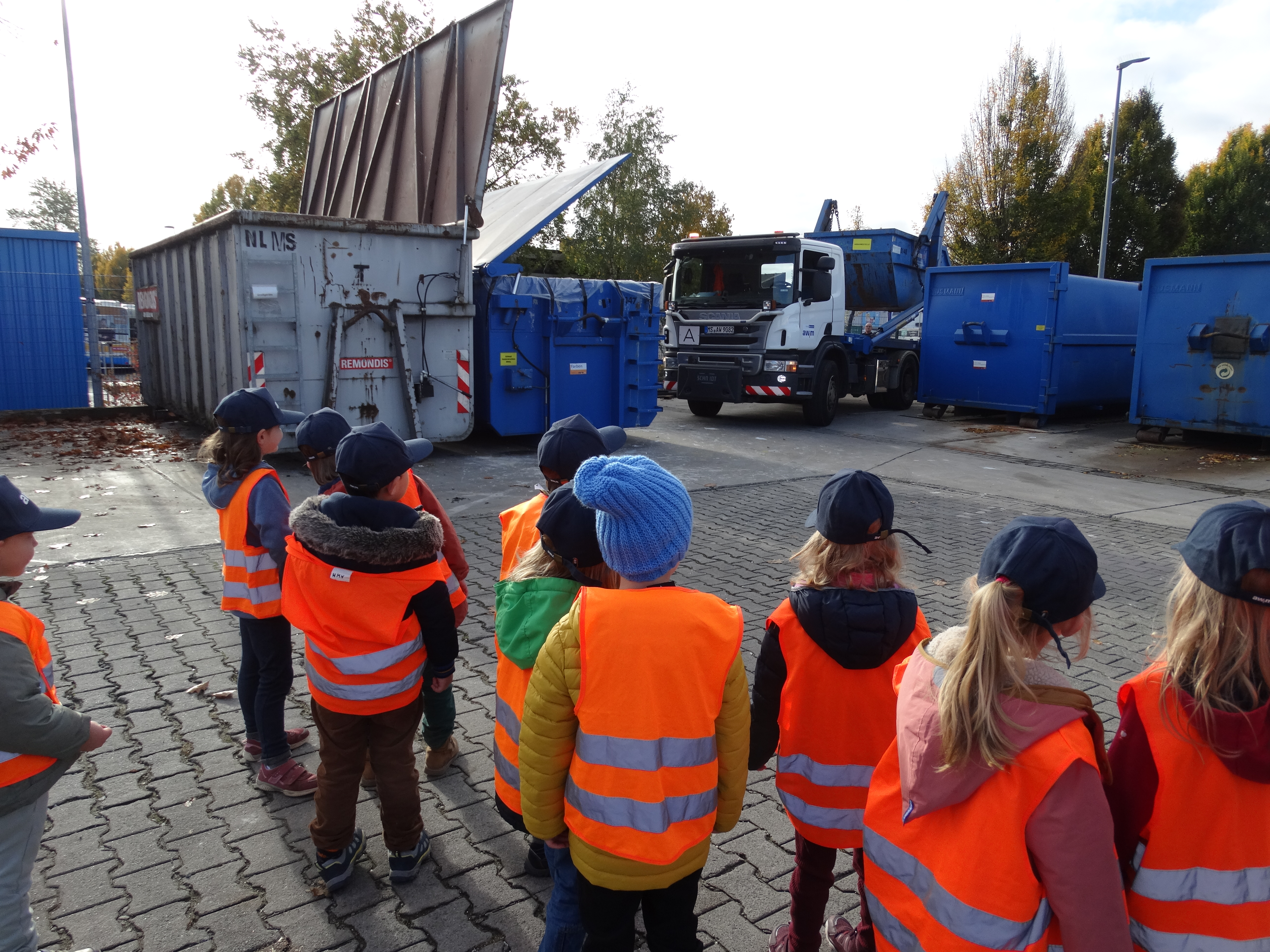 Kindergruppe vor Containern der awm
