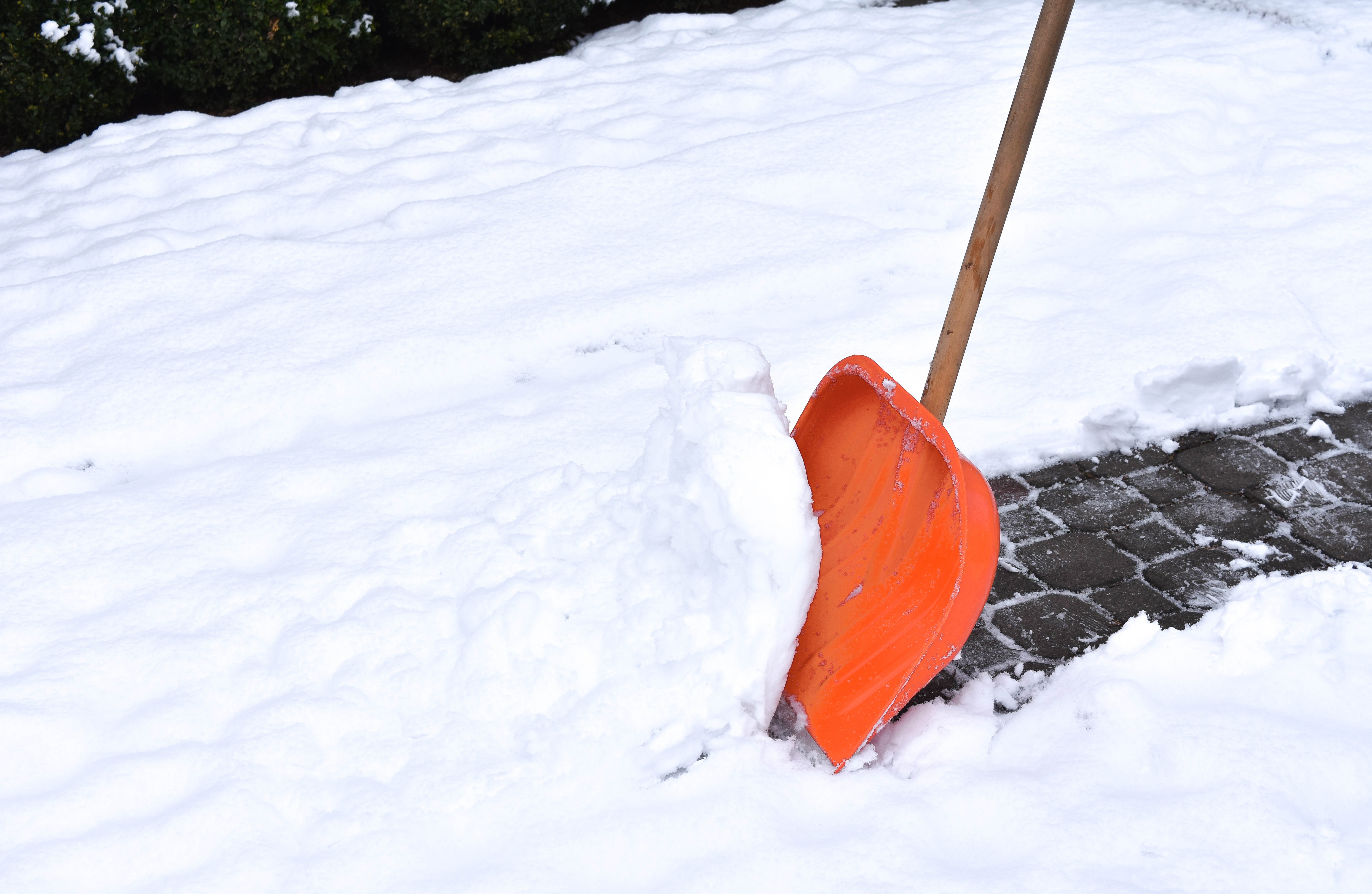 Schneeschieber befreit den Gehweg von Schnee
