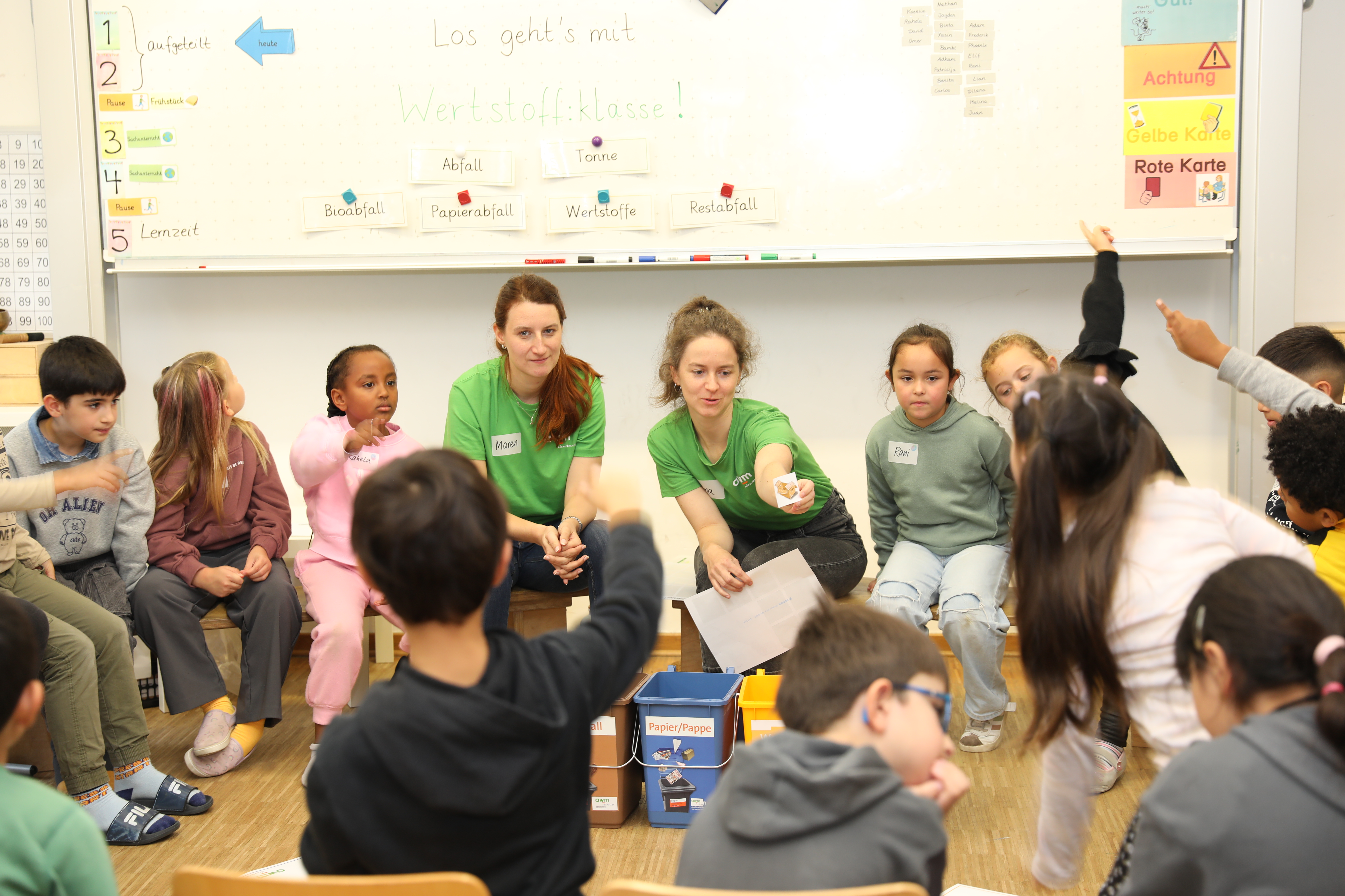 Schülerinnen und Schüler der Norbertschule im ersten Unterrichtsmodul der „Werstoff:klasse“ mit den awm-Nachhaltigkeitspädagoginnen Maren Wolff (Mitte l.) und Ana Stevanović (Mitte r.)