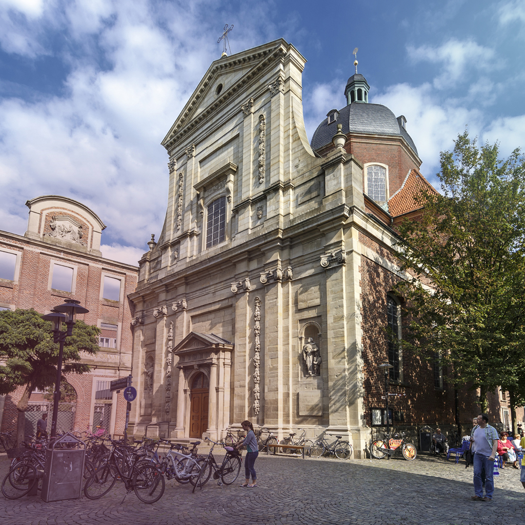 Die Dominikanerkirche in Münster von unten fotografiert, vor hellblauem Himmel.