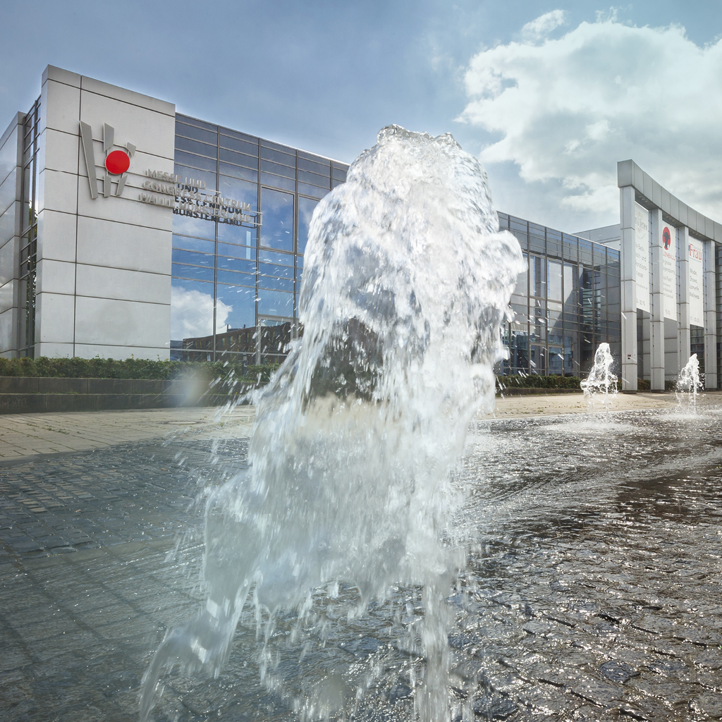 Eine Wasserfontäne kommt aus dem Springbrunnen vor dem Messe- und Congress Centrum Halle Münsterland