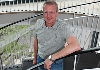 Markus Koers ist bei der Stadt Münster seit 11 Jahren für die Hausdienste und den Service zuständig - er steht auf der Wendeltreppe in Stadthaus 1 und schaut in die Kamera.