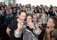 Jan Josef Liefers steht vor einer großen Gruppe vorwiegend weiblicher Fans und macht mit ihnen Selfies bei der Premiere von 'Schlangengrube' 2018 im Cineplex Münster