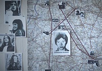 Eine Landkarte des Münsterlands ist mit Markierungen und angehefteten Fotos von jungen Frauen versehen.