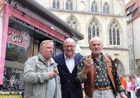Oberbürgermeister Markus Lewe mit Axel Prahl und Claus Dieter Clausnitzer stehen neben einem Eiswagen vor dem historischen Rathaus von Münster