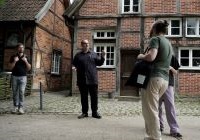 Eine Gruppe steht vor historischen Bauwerken im Mühlenhof in Münster