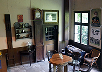 Eine alte Standuhr, Tisch und Stühle im Wohnraum