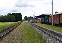 Alter Bahnhof Lette - Außenansicht, Blick über die Gleise auf den Bahnhof und alte Zugteile