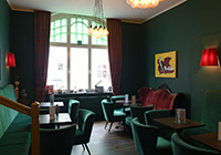 Das kleine Café im Kinofoyer - Blick über grüne Sessel zum Fenster