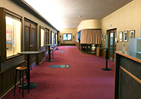 Das Theater am Wall in Warendorf von außen  - Der Eingangsbereich von Innen, Blick in ein im 50er Jahre-Stil erhaltenes Foyer mit Garderobe und Stehtischen